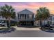 Inviting coastal home with a cozy screened porch, neutral siding, mature palm trees, and convenient covered parking at 708 Ashland Ave., North Myrtle Beach, SC 29582