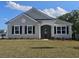 Charming single-story home with light gray siding, black shutters, and a well-maintained lawn on a sunny day at 725 Choctaw Dr., Conway, SC 29526