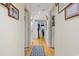A long hallway with light colored walls and wood floors, featuring framed artwork and several doors at 806 Conway St. # 116, North Myrtle Beach, SC 29582