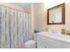 Bright bathroom with a shower featuring colorful striped shower curtain and white vanity at 808 Atlantic Commons Dr., Surfside Beach, SC 29575