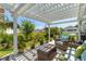 Inviting covered patio with a pergola, wicker furniture, and view of the manicured backyard at 808 Atlantic Commons Dr., Surfside Beach, SC 29575