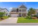 Charming two-story home featuring a welcoming front porch, well-manicured lawn, and beautiful landscaping at 808 Atlantic Commons Dr., Surfside Beach, SC 29575