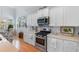Modern kitchen with white cabinets, stainless steel appliances, and views to an adjacent dining area at 808 Atlantic Commons Dr., Surfside Beach, SC 29575