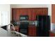 Well-equipped kitchen featuring wooden cabinetry, black appliances, and a stylish backsplash at 843 Brookline Dr., Myrtle Beach, SC 29579