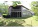 The back of the unit features a screened porch and enclosed space with several windows, overlooking the backyard at 861 Tall Oaks Ct. # D-61, Myrtle Beach, SC 29588