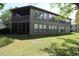 The back of the unit features a screened porch and enclosed space with several windows, overlooking the backyard at 861 Tall Oaks Ct. # D-61, Myrtle Beach, SC 29588