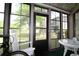 Enclosed porch with view of backyard, glass table and chairs and bicycle at 861 Tall Oaks Ct. # D-61, Myrtle Beach, SC 29588