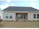 Back exterior showing the covered porch and backyard at 8719 Baton Rouge Ave Nw, Calabash, NC 28467