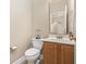 Half bathroom features a wood vanity, white sink and toilet, neutral walls, and decorative mirror at 886 Carolina Farms Blvd., Myrtle Beach, SC 29579