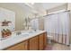 Bathroom with double sink vanity, neutral walls, tile floor, white shower curtain, and decorative accents at 886 Carolina Farms Blvd., Myrtle Beach, SC 29579