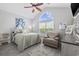 Bright bedroom features a vaulted ceiling, ceiling fan, large window, stylish decor, and gray wood-look floors at 886 Carolina Farms Blvd., Myrtle Beach, SC 29579