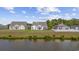 A view of the back of three houses with well-manicured lawns, bordering a lake at 886 Carolina Farms Blvd., Myrtle Beach, SC 29579