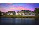 Rear view of residences from across a tranquil lake, set against a backdrop of colorful sunset skies at 886 Carolina Farms Blvd., Myrtle Beach, SC 29579