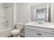 Clean and modern bathroom with shower/tub combo, a white vanity with a quartz countertop, and a large mirror at 889 Ireland Dr., Longs, SC 29568