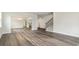 Open-concept living area with wood-look floors, staircase, and multiple entryways at 889 Ireland Dr., Longs, SC 29568