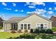 Charming backyard view with a screened-in porch, lush lawn, and meticulously maintained landscaping at 9169 Nw Oldfield Rd., Calabash, NC 28467