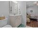 Bright bathroom features a white vanity with framed mirror and a view into the bedroom at 9169 Nw Oldfield Rd., Calabash, NC 28467