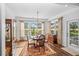 Bright dining area featuring a chandelier, wooden floors, and sunlit windows at 9169 Nw Oldfield Rd., Calabash, NC 28467