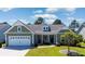Charming single-story home featuring a manicured lawn, tidy landscaping, and a convenient two-car garage at 9169 Nw Oldfield Rd., Calabash, NC 28467