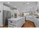 Bright kitchen boasts a large island, stainless steel appliances, and sleek white cabinetry at 9169 Nw Oldfield Rd., Calabash, NC 28467