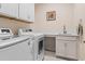 Laundry room features side-by-side washer and dryer, storage cabinets, and countertop space at 9169 Nw Oldfield Rd., Calabash, NC 28467