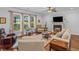 Sunlit living room showcasing golf course views, a fireplace, and hardwood floors; a relaxing space at 9169 Nw Oldfield Rd., Calabash, NC 28467
