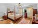 Spacious bedroom with a four-poster bed, plush bedding, and natural light creating a tranquil retreat at 9169 Nw Oldfield Rd., Calabash, NC 28467