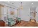 Bright sitting area features hardwood floors, white trim, and two comfortable, light green armchairs at 9169 Nw Oldfield Rd., Calabash, NC 28467