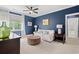Stylish living room with blue accent wall, elegant curtains, soft carpet, and ceiling fan at 93 Knotty Pine Way, Murrells Inlet, SC 29576