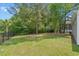 Lush backyard with mature trees, green grass, and privacy fencing at 100 Oak Leaf Dr., Longs, SC 29568