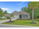 Single-story home boasting a well-maintained lawn with flowering beds and palm trees at 100 Oak Leaf Dr., Longs, SC 29568