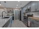 Well-lit kitchen with gray cabinetry, stainless steel appliances, and granite countertops at 100 Oak Leaf Dr., Longs, SC 29568
