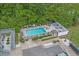 Aerial view of a pool area with lounge chairs, picnic tables, and surrounding greenery at 100 Oak Leaf Dr., Longs, SC 29568