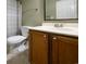 A bathroom boasts a wooden vanity with white countertop, a sink, and a nearby toilet with striped shower curtain at 112 3Rd Ave. S # B, Surfside Beach, SC 29575