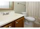 Bathroom with oak vanity, white sink, toilet and a shower/tub with curtain at 112 3Rd Ave. S # B, Surfside Beach, SC 29575