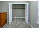 A bedroom closet features open bi-fold doors, a shelf, and neutral carpeting for efficient organization at 112 3Rd Ave. S # B, Surfside Beach, SC 29575