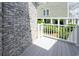 The outside deck area is framed by a brick facade and offers a partial view of surrounding greenery at 112 3Rd Ave. S # B, Surfside Beach, SC 29575