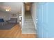 A bright entryway with hardwood floors, a carpeted staircase, and a living room with a ceiling fan at 112 3Rd Ave. S # B, Surfside Beach, SC 29575