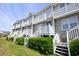 Angle of a townhouse complex, showcasing the white stairs and shrubbery landscaping at 112 3Rd Ave. S # B, Surfside Beach, SC 29575