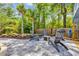 Cozy outdoor patio with fire pit, Adirondack chairs, lush landscaping, and privacy fence at 1203 Crooked Oak Dr., Pawleys Island, SC 29585