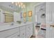 Bright bathroom with a double sink vanity, neutral decor, and an open doorway to the bedroom at 1203 Crooked Oak Dr., Pawleys Island, SC 29585