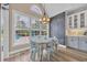 Bright dining area with large window overlooking pool and yard, featuring stylish chandelier and chalkboard wall at 1203 Crooked Oak Dr., Pawleys Island, SC 29585