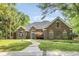 Charming brick home featuring a lush, landscaped yard and inviting walkway at 1203 Crooked Oak Dr., Pawleys Island, SC 29585