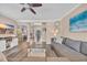 Comfortable living room with wood floors, ceiling fan, and views to dining room and front door at 1203 Crooked Oak Dr., Pawleys Island, SC 29585