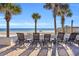 Ocean view with lounge chairs on a patio and a pier in the background at 1203 Crooked Oak Dr., Pawleys Island, SC 29585