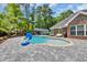 Backyard pool with a tanning ledge, brick home, an outbuilding and outdoor cooking area at 1203 Crooked Oak Dr., Pawleys Island, SC 29585