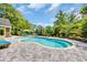 Sparkling backyard pool with a tanning ledge and poolside seating, surrounded by lush landscaping at 1203 Crooked Oak Dr., Pawleys Island, SC 29585