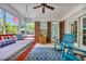 Relaxing screened porch featuring a daybed swing, blue rocking chairs, and view of the pool at 1203 Crooked Oak Dr., Pawleys Island, SC 29585