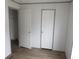 Bedroom with closet entrances, wood-look flooring, and white doors at 1242 Carrie Bell Ln, Myrtle Beach, SC 29577
