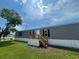 Manufactured home with well-maintained lawn and wooden porch and stairs at 1242 Carrie Bell Ln, Myrtle Beach, SC 29577